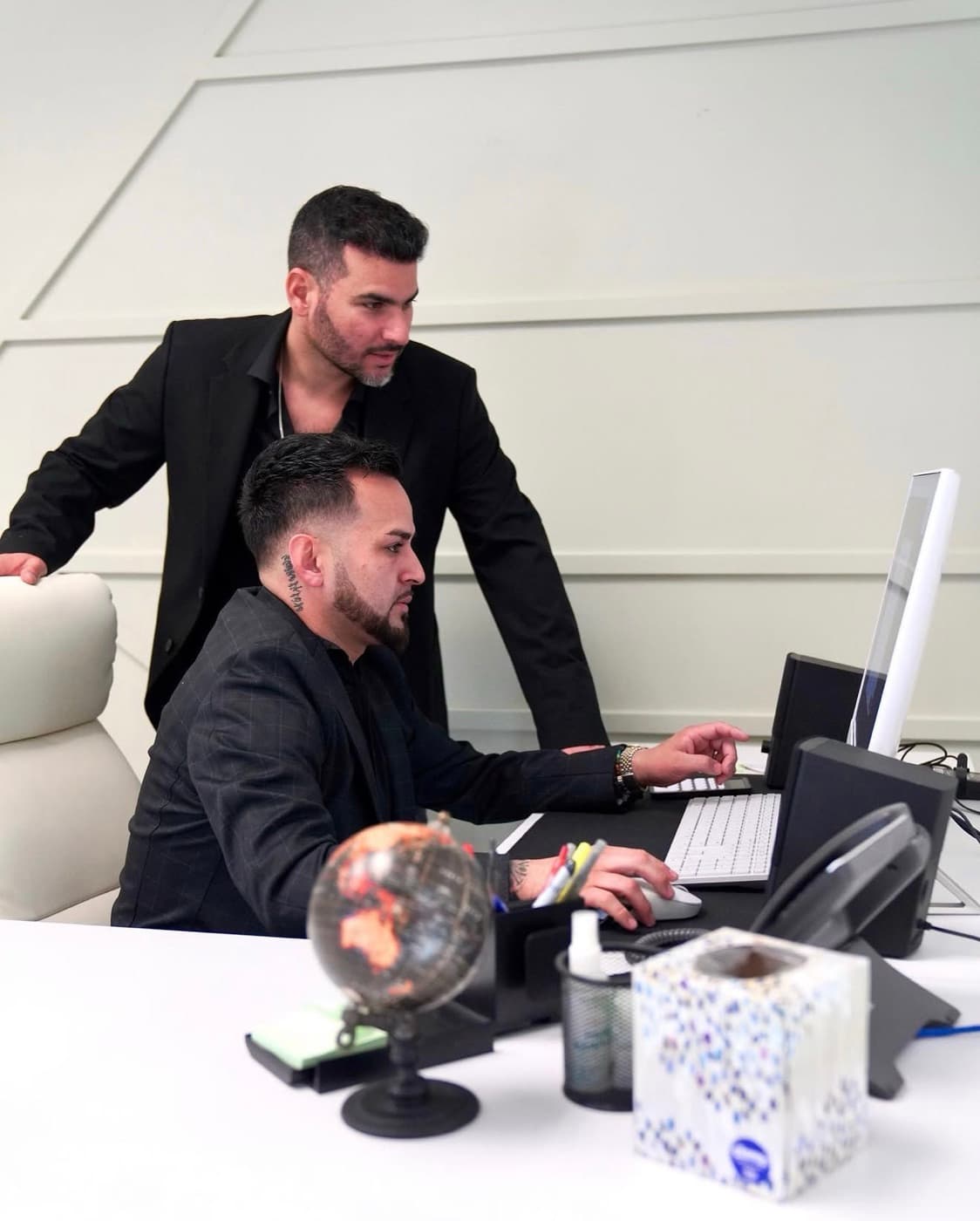 Two remodeling marketers reviewing campaign results on a laptop