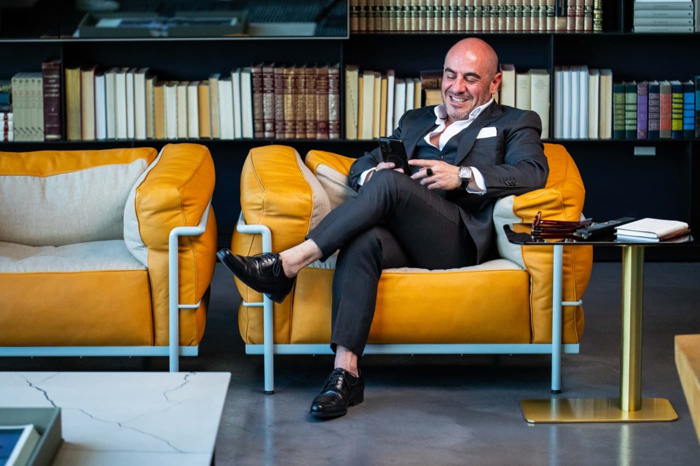 Living Penthouse founder seated on a yellow couch